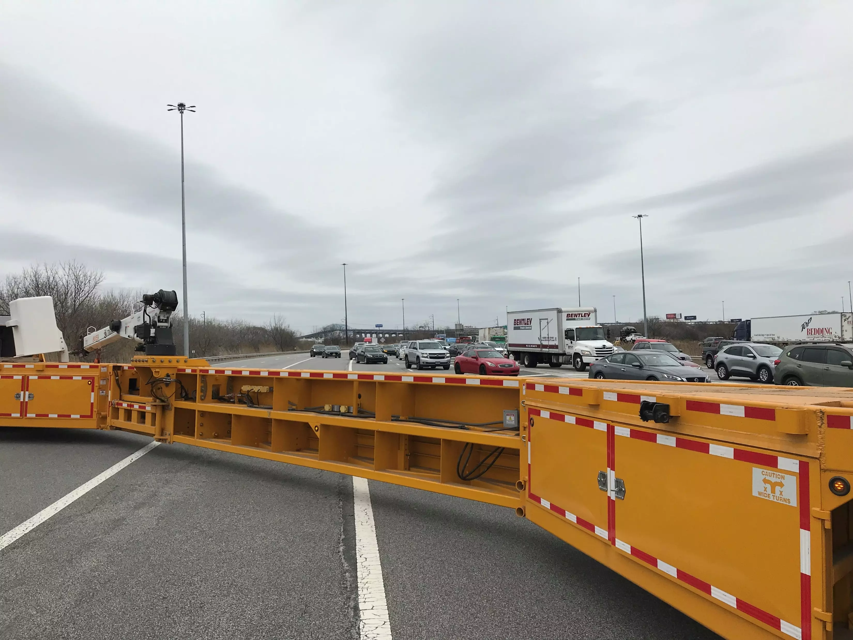 An image of a 110-foot-long yellow mobile truck barrier being used to transition traffic and protect incident management crews.